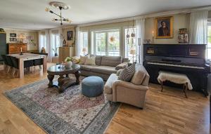 波什格伦Cozy Home In Porsgrunn With Heated Swimming Pool的带沙发和钢琴的客厅