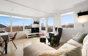 森讷比3 Bedroom Awesome Home In Juelsminde的客厅配有白色家具和大窗户