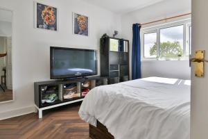 卡迪夫Garden Station Dwelling in Rumney的一间卧室设有平面电视和一张床。