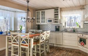 艾尔夫达伦Stunning Home In lvdalen With Sauna的厨房配有白色橱柜和桌椅