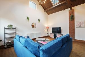 诺斯利Victorian Summer Retreat in Liverpool的客厅配有蓝色的沙发和电视
