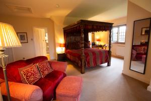 查姆斯特小法院酒店的一间卧室配有四柱床和沙发