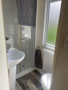 韦茅斯Littlesea Haven fleetview的一间带水槽和卫生间的浴室以及窗户。
