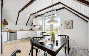 哈夫維格Lovely Home In Hvide Sande With Wifi的厨房以及带桌椅的用餐室。