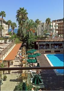 安塔利亚Ambassador Hotel & Spa- All Inclusive的享有带游泳池和绿色遮阳伞的度假村景色