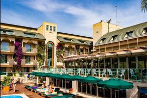 安塔利亚Ambassador Hotel & Spa- All Inclusive的一个带游泳池和桌椅的度假酒店