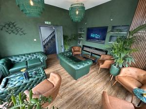 布莱克浦Hotel Neon的客厅配有沙发、椅子和电视