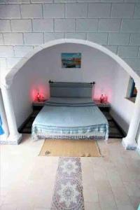 比塞大Dar Sandra Bizerte的拱门中间的一间设有床铺的房间