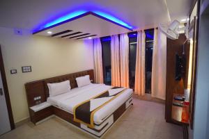 JasidihHotel Asha Inn的一间卧室配有一张蓝色的灯光床