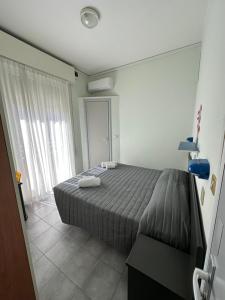 里米尼奥地利酒店的一间卧室配有一张床,上面有两条毛巾