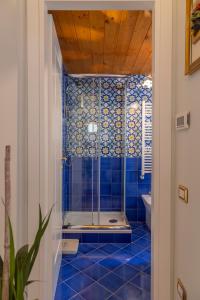 维耶特里The House of Flowers的蓝色瓷砖浴室配有淋浴和卫生间。