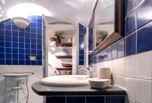 维耶特里The House of Flowers的浴室配有水槽和蓝色瓷砖墙。