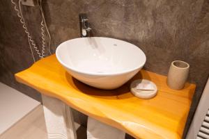 普雷多雷戴朗吉罗酒店的木桌上设有白色碗水槽的浴室