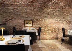 布鲁日马勒贝格酒店的一间设有两张桌子和砖墙的用餐室