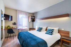 圣梅尔埃格利斯Hotel Restaurant Le Sainte Mere的一间卧室配有一张带蓝色毯子的大床