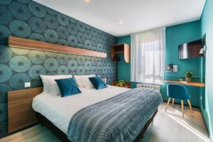 圣梅尔埃格利斯Hotel Restaurant Le Sainte Mere的一间卧室配有一张带蓝色墙壁的大床