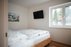 PetschnitzenPremium Apartments Monterra的白色的卧室设有床和窗户
