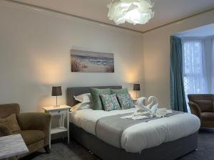 廷塔杰尔Tintagel Arms Bed and Breakfast的一间卧室配有一张带两个天鹅的床