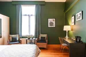 布鲁日马勒贝格酒店的一间卧室设有绿色的墙壁、一张床和一张书桌
