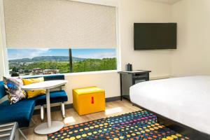 诺克斯维尔Aloft Knoxville West的配有一张床、一张书桌和一扇窗户的酒店客房