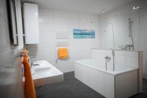 PetschnitzenPremium Apartments Monterra的白色的浴室设有浴缸和水槽。