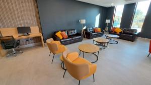 圣地亚哥Hotel Diego de Almagro Pudahuel Aeropuerto的带沙发和桌椅的客厅