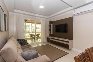 邦比尼亚斯006 - Amplo 3 quartos com vista mar em Bombas的带沙发和电视的客厅