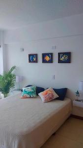 波拉马尔Apart. con aire, frente al mar的卧室配有一张墙上三幅照片的床