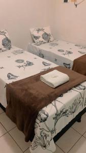 阿拉皮拉卡CONFORT HOTEL ARAPIRACA的两张睡床彼此相邻,位于一个房间里