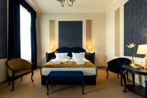 凯奇凯梅特Boutique Hotel Gaia的一间卧室配有一张带两把椅子和一张桌子的床。