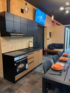 迪瓦伊巴雷Diamond Hostel的一间带炉灶的厨房和一间带桌子的用餐室