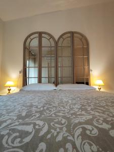 蒙蒂基亚里Garda Relais Antica Romelia的一间卧室设有两张床,墙上有两盏灯。