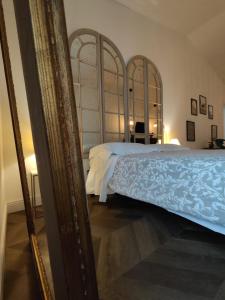 蒙蒂基亚里Garda Relais Antica Romelia的一间卧室配有一张床和镜子