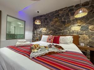 佩尼多佩内多圣达菲旅馆的一间卧室设有一张带石墙的大床