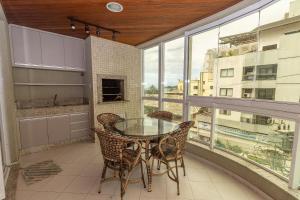 邦比尼亚斯006 - Amplo 3 quartos com vista mar em Bombas的阳台配有玻璃桌和椅子。