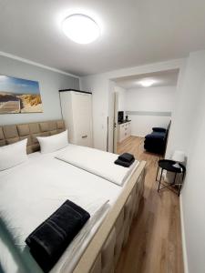 维斯马潘森奥普斯特尔酒店的一间卧室配有一张带白色床单的大床