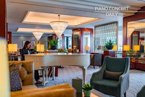 布拉格Grand Hotel Prague Towers的中间设有钢琴的酒店大厅