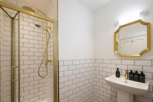 亨利昂泰晤士Flower Pot Hotel的浴室配有盥洗盆和带镜子的淋浴
