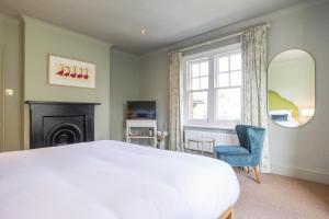 亨利昂泰晤士Flower Pot Hotel的卧室配有一张白色大床和一把椅子