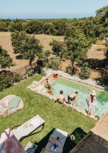 阿尔加约拉Residence CASE DI PI GNA, deux magnifiques villas indépendantes avec piscines individuelles , proches de la plage d'Algajola的一群人坐在游泳池里