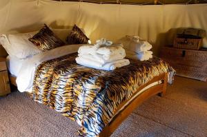 ThirklebyBurtree Country House and Retreats Tipi的一张床上有动物印花的床单和毛巾