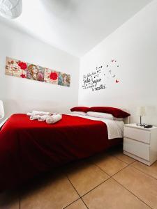 科森扎Sunrise Home的一间卧室配有红色床单和红色枕头。