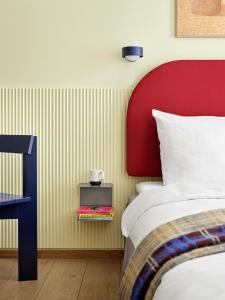 哥本哈根BRIK Apartment Hotel的一间卧室配有一张床和一个红色床头板