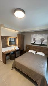 欧拉努波利斯日落酒店的一间卧室配有一张床和一张书桌