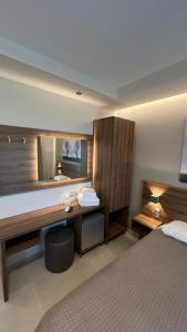 欧拉努波利斯日落酒店的一间卧室配有一张床、一张书桌和一面镜子