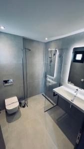 欧拉努波利斯日落酒店的带淋浴、卫生间和盥洗盆的浴室