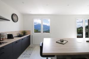 NancesComfortable Chalet - View of Lake Aiguebelette的厨房配有木桌和2扇窗户。