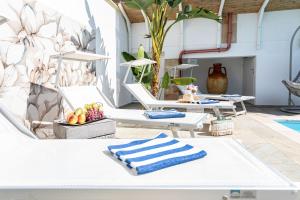 托雷苏达Villa Geraldina con piscina的一组白色躺椅,上面有毛巾