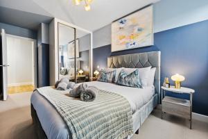 南安普敦Luxurious 1 Bed Stylish Apt, Southampton by Blue Puffin Stays的一间卧室配有一张带蓝色墙壁的大床