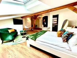GalsApart-Hôtel Pont-de-Thielle的一间卧室配有一张大床和一张绿色椅子